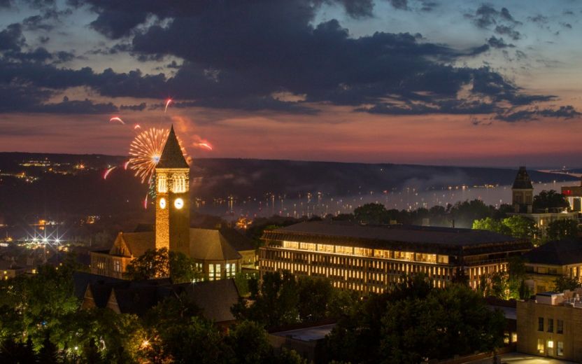 fireworks exploding next to McGraw Tower at evening
