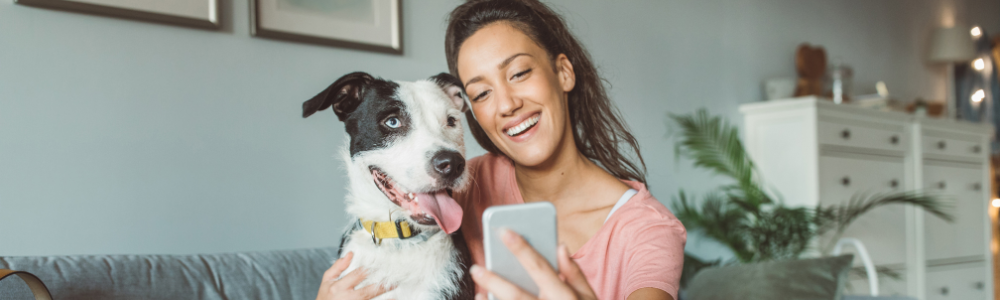 woman on couch with cute dog taking selfie together