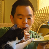 Stephen Kim and cat trying to eat his slice of pie