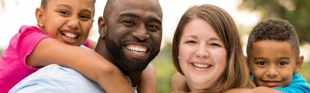 mixed race couple and children smiling outdoors