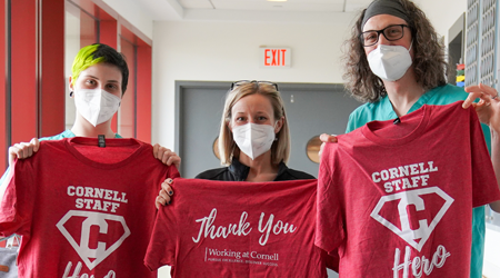three employees posing with Cornell Heroes shirts