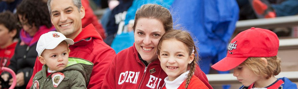 family in Cornell clothes at indoor sporting event