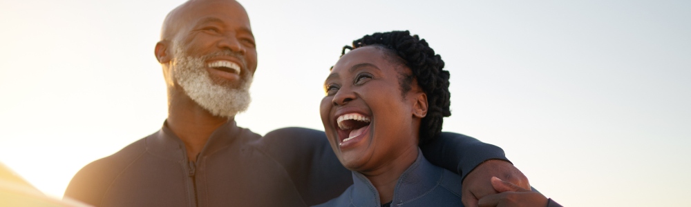 mature Black man and woman outdoors laughing