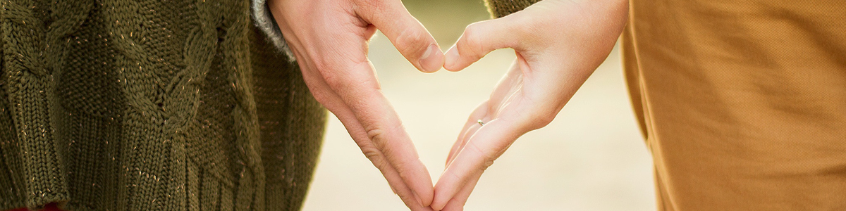two people's hands together creating a heart shape