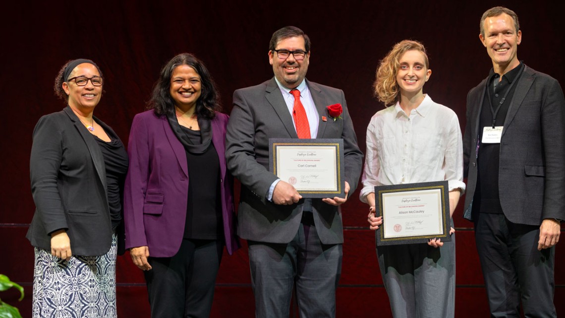 group of people on stage with awards certificates