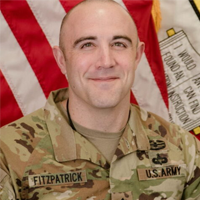 portrait of man in army uniform in front of flag