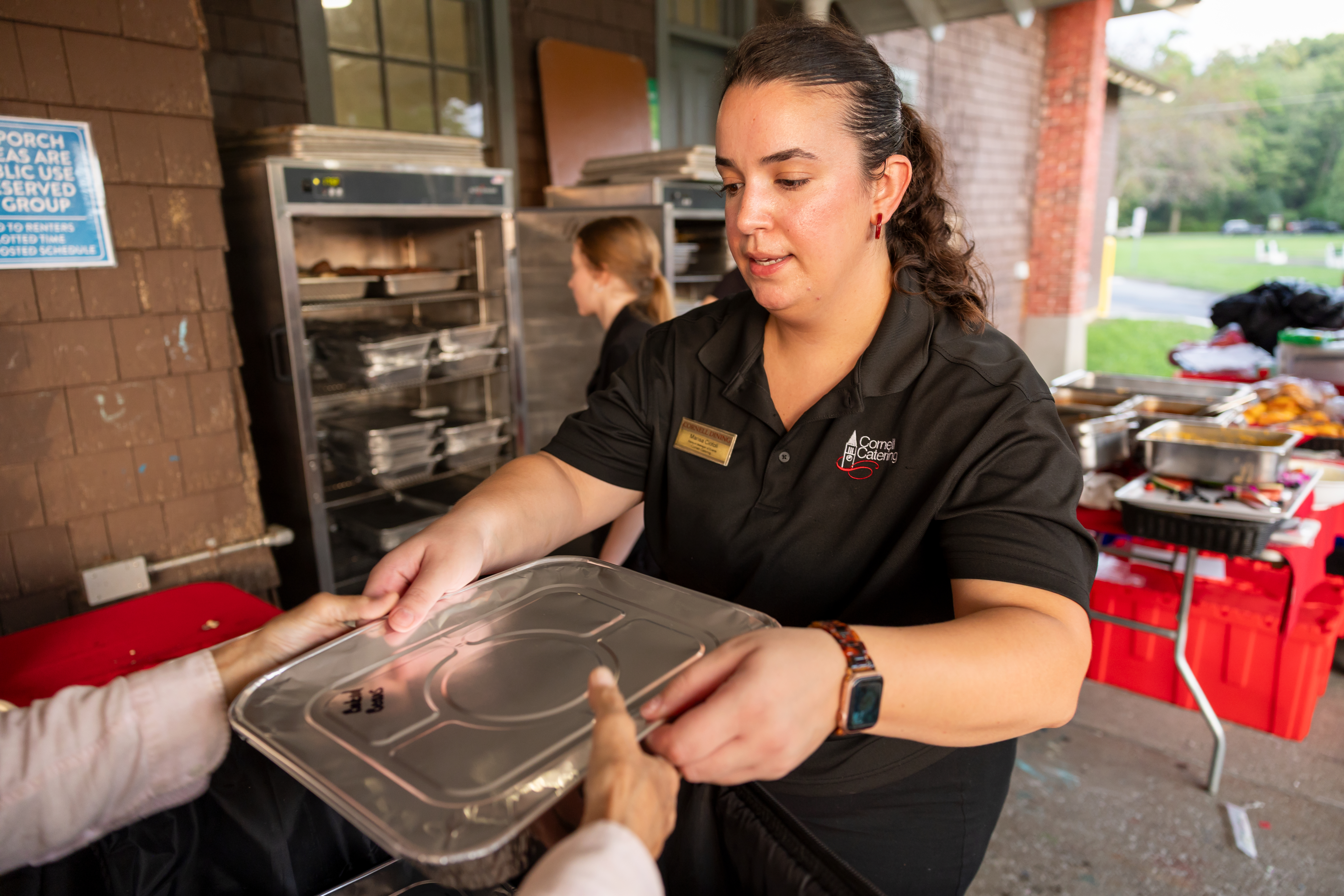 Marisa Ciotoli handing off packaged food