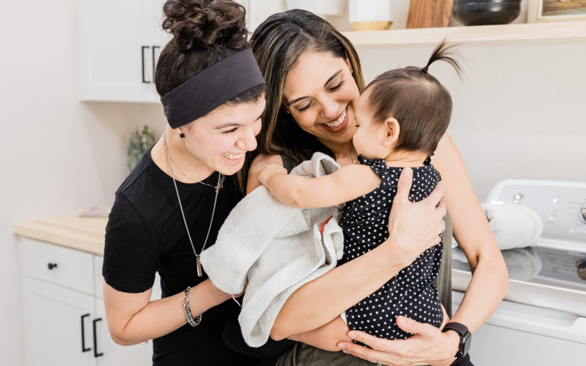 two women snuggling with baby in kitchen
