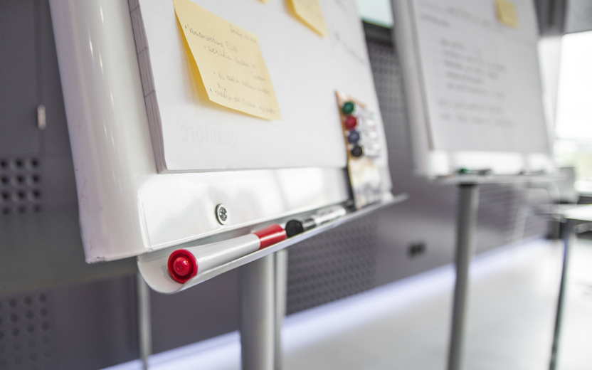 closeup of white board, markers, post-it notes