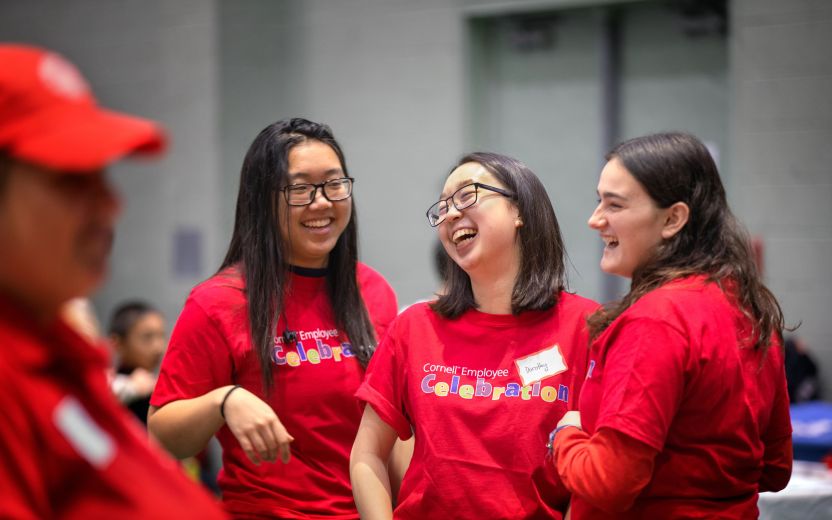 three female students in Cornell event tshirts laughing