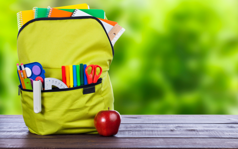 child's bright green backpack full of colorful supplies