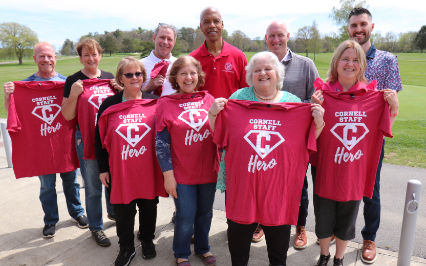team posing outdoors wearing red "Cornell Heroes" tshirts