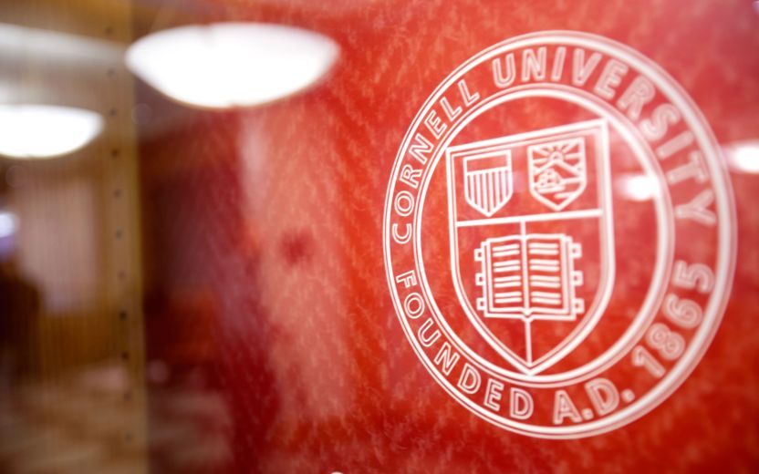 Cornell University seal on red wall