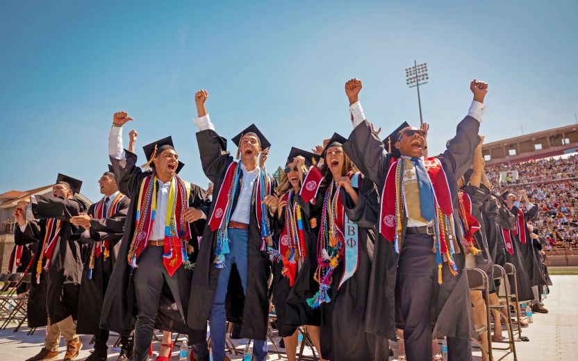 group of graduates cheering at commencement