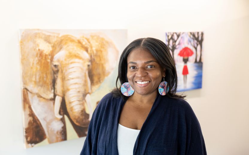 Photo of Qiana Watson posing in front of paintings