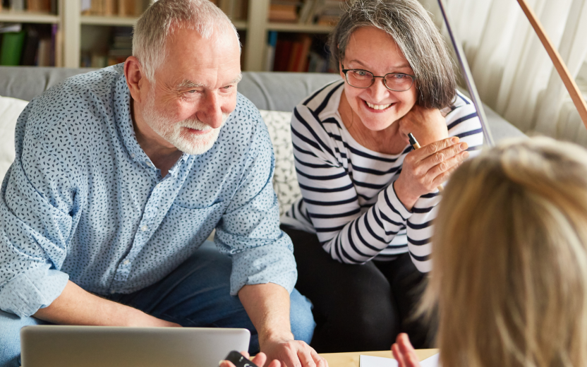 senior couple smiling during meeting with consultant at home