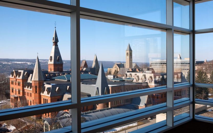 older Cornell buildings seen through modern window
