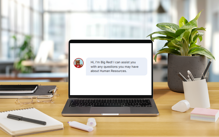 laptop on desk displaying chatbot opening: Hi, I'm Big Red! I can assist you with any questions you may have about Human Resources.