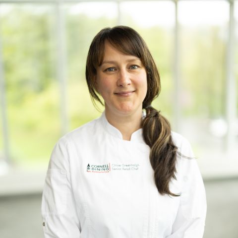 portrait of Chloe Greenhalgh in chef jacket near sunny window