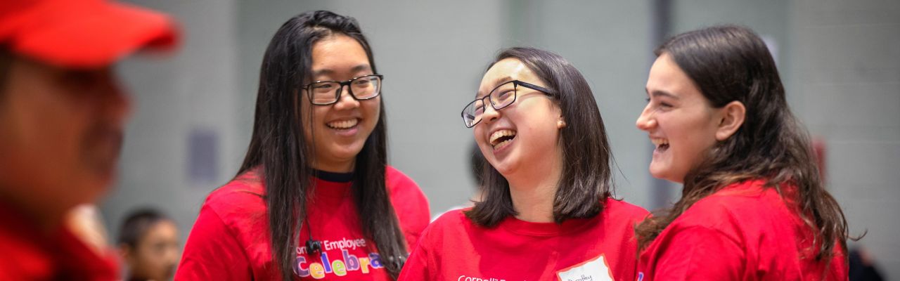 three female students in Cornell event tshirts laughing