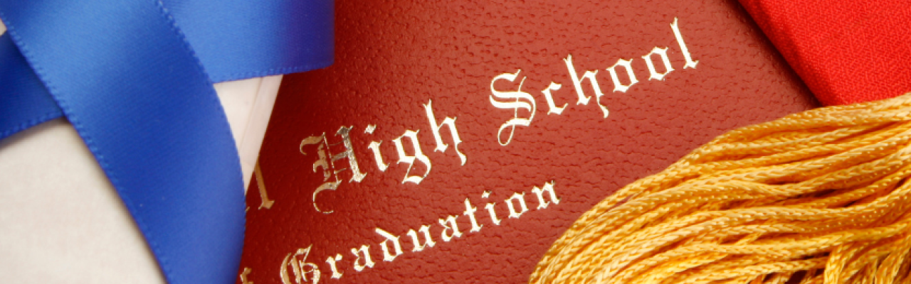 closeup of diploma and leatherette folder with words "High School Graduation"