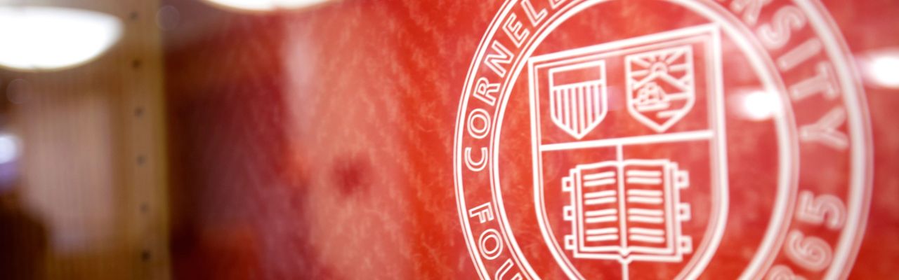 Cornell University seal on red wall