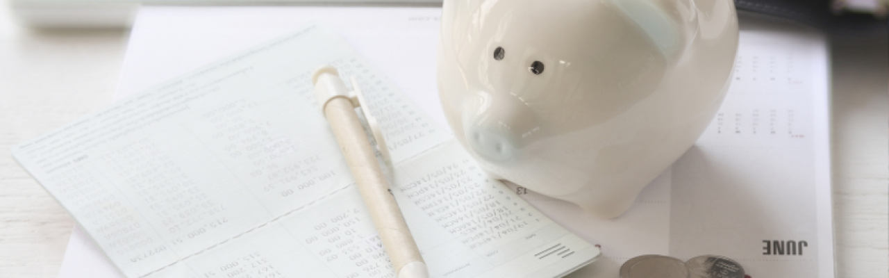 piggy bank, financial statements, keyboard on desk