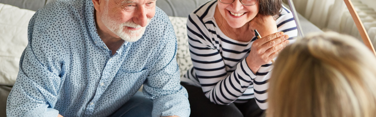 senior couple smiling during meeting with consultant at home