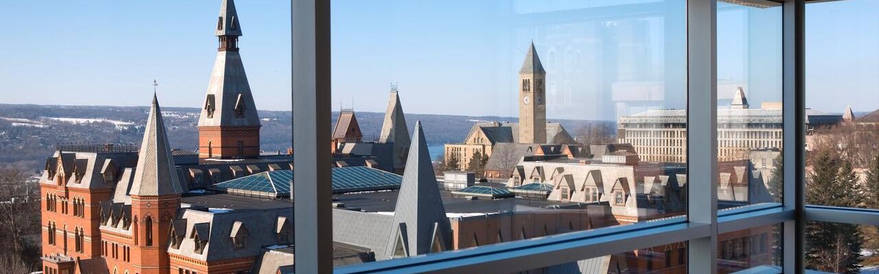older Cornell buildings seen through modern window